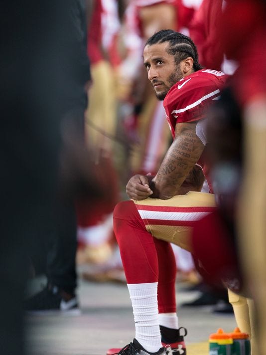 Colin Kaepernick kneeling on the sideline.